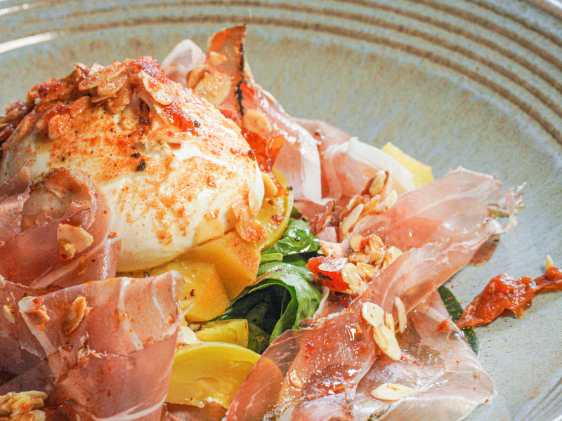 Ensalada de burrata italiana con polvo de tomate y speck