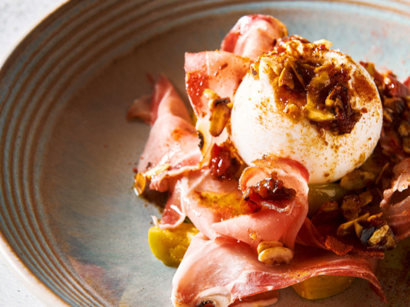 Ensalada de burrata italiana con polvo de tomate y speck