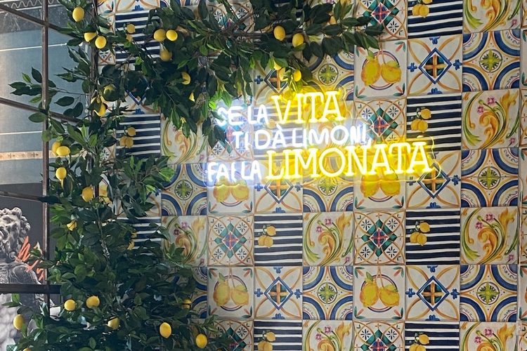 Pared de azulejos con limoneros y el neón Se la vita ti dà limoni, fai la limonata