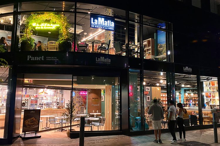 Fachada iluminada de noche del restaurante La Famiglia se sienta a la mesa en Escaldes-Engordany, Andorra